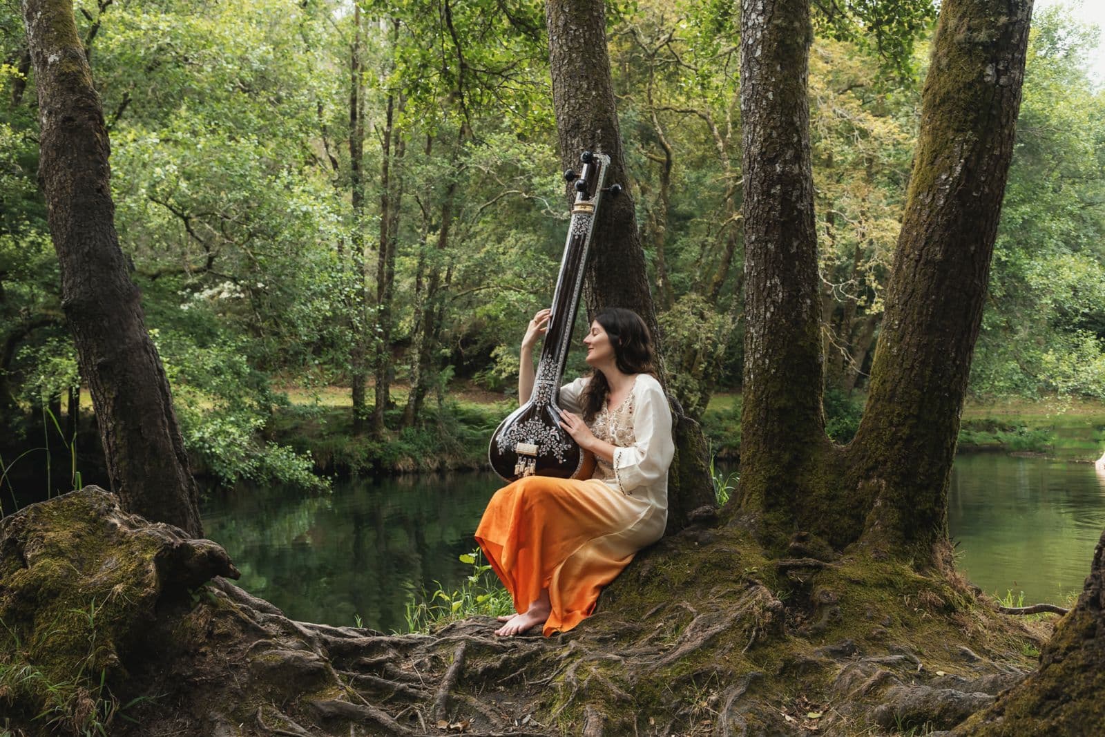 Alicia Corral con tanpura en la naturaleza